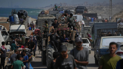 Displaced palestinians flee northern gaza strip as they walk carrying their belongings along the coastal road near wadi gaza.jpg
