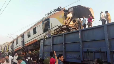 People gather at the spot as the coaches of a memu train and a goods train collided.jpg